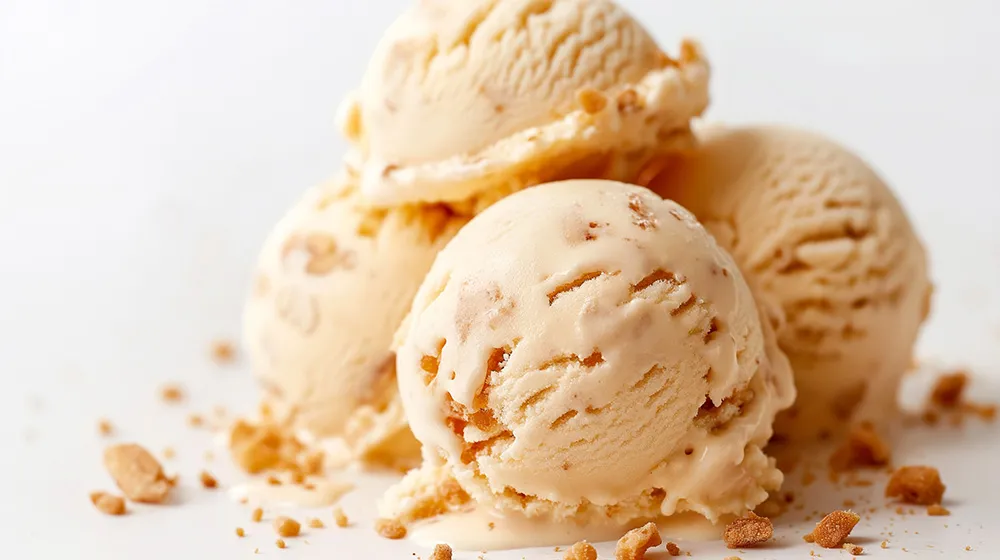 Scoops of honeycomb swirl gelato with crumbs of honeycomb sprinkled on top