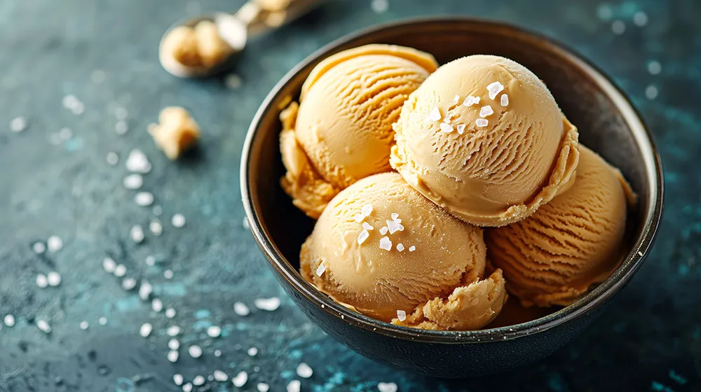 Scoops of seal salted caramel ice cream with sprinkles of sea salt over the top