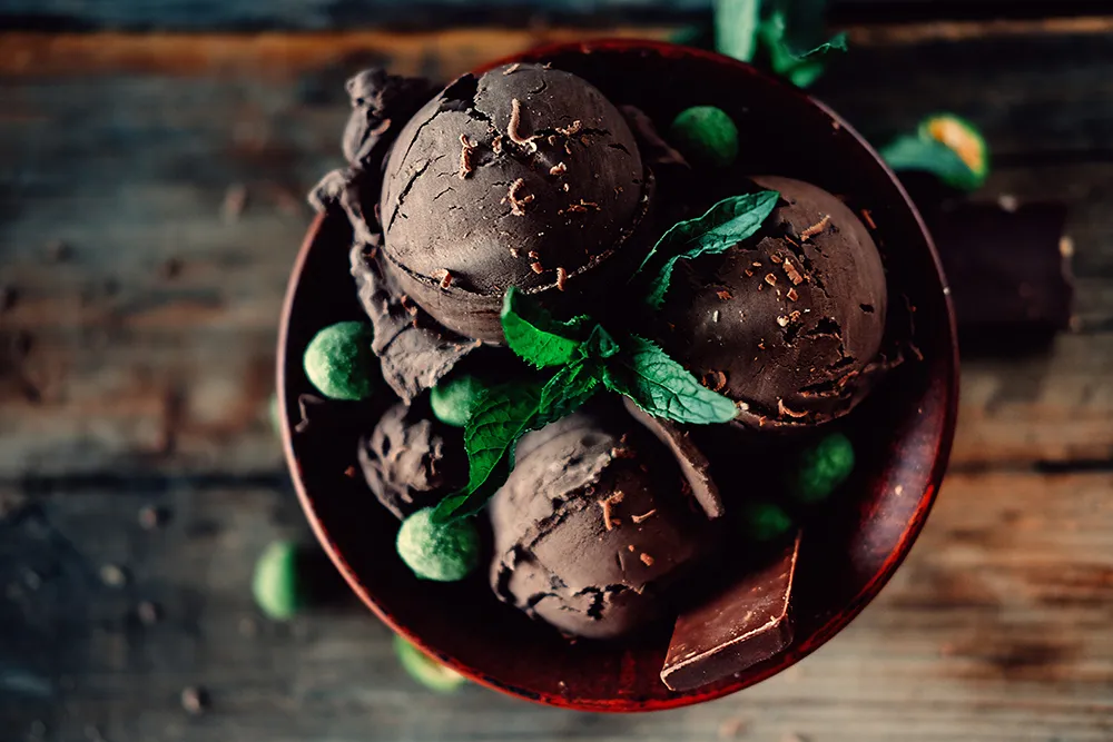 Scoops of after dark gelato sitting in a bowl with mint on top